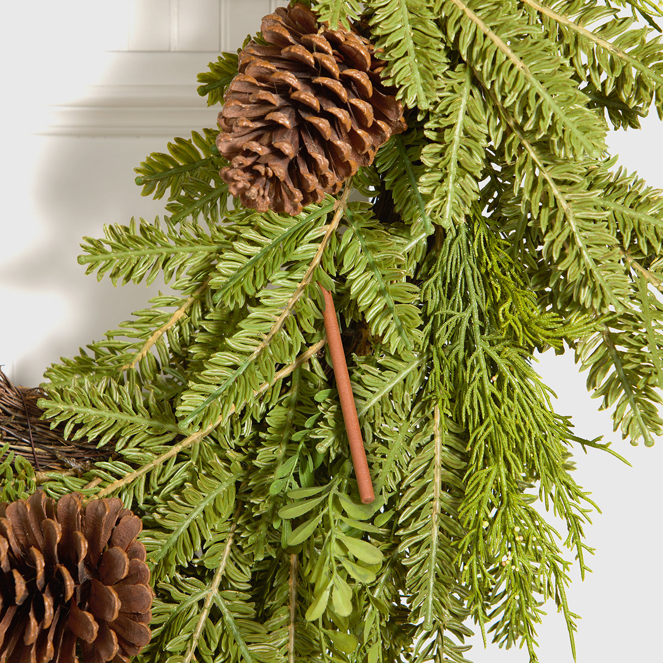 Scentsicles scented ornament stick nestled in a festive wreath of pine branches and pinecones, bringing the fresh scent of a real Christmas tree to holiday decor.