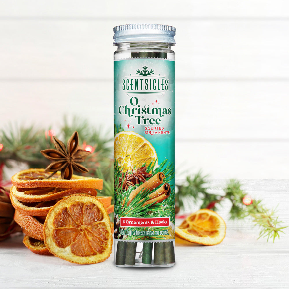 Scentsicles O Christmas Tree scented ornaments bottle with six ornaments and hooks, placed among dried orange slices, cinnamon sticks, and star anise, evoking the traditional fragrance of a holiday evergreen.